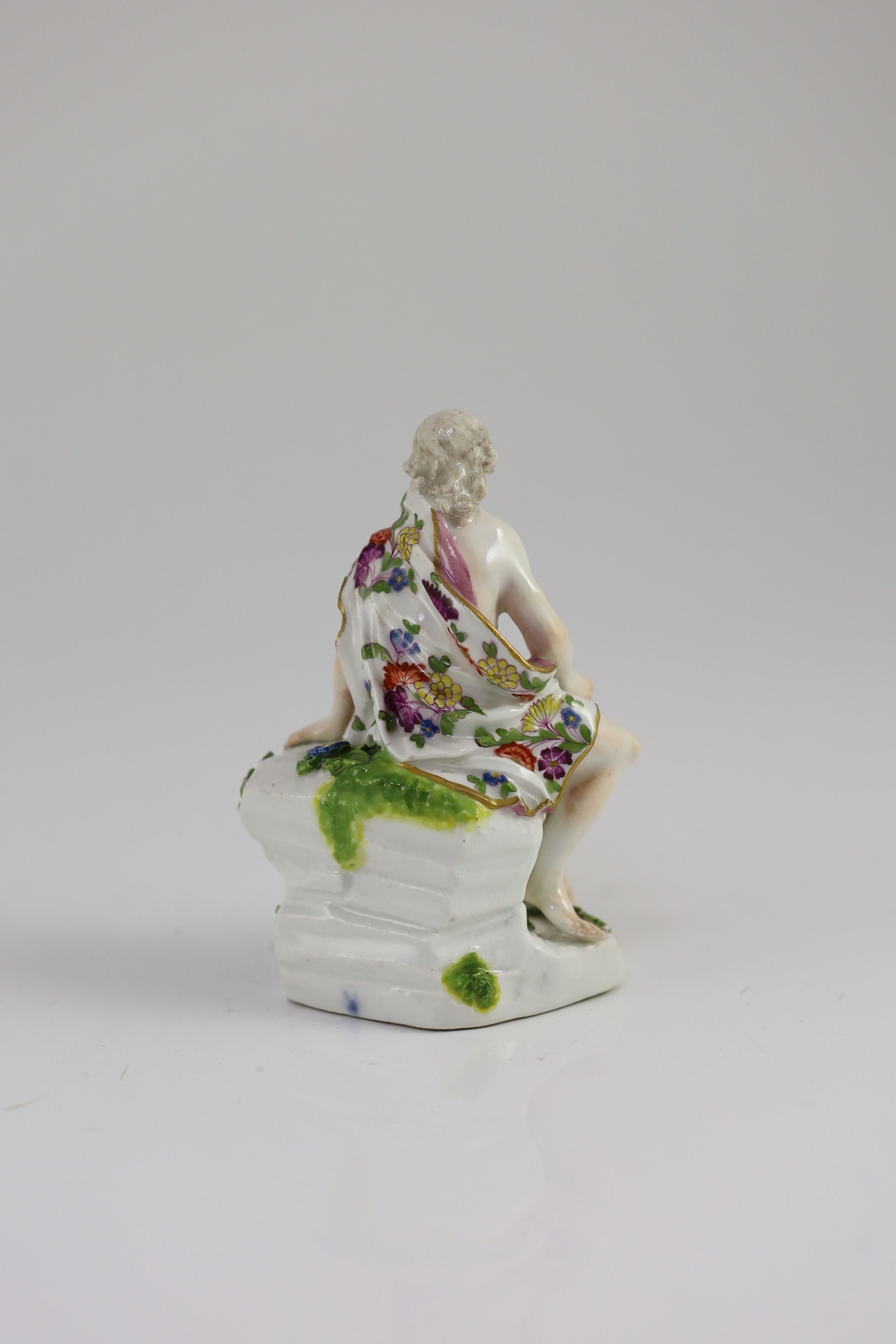 A Meissen figure of a classical male seated on rock, mid 18th century, 12cm high, some restoration